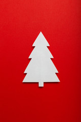 Christmas tree made of paper on a red background. Merry Christmas advertising for covers, invitations, posters, banners, flyers, placards.