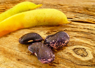 Pink and black large ripe raw beans on old  wooden background. Variety of protein rich colorful fresh raw beans. Selective soft focus, close up.