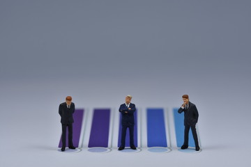 Mini business men standing on paper with blua and purple lines printed on it