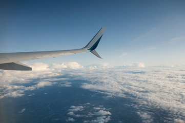 Fototapeta premium View of wing airplane on cloudy in blue sky