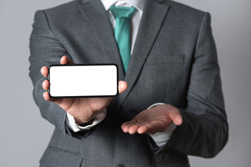 Businessman showing a blank screen mobile phone with copy space. Contact us. Financial advisor.