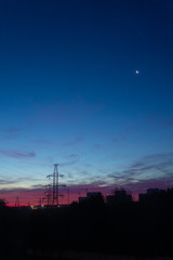 Power lines on a pink sky background. Sunrise over the forest