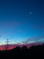 Power lines on a pink sky background. Sunrise over the forest