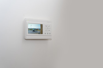 video intercom on a white wall near the entrance door to the apartment