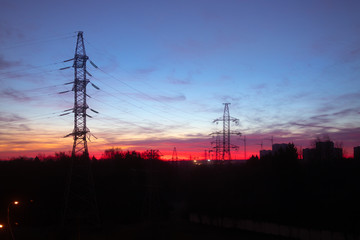 Power lines on a pink sky background. Sunrise over the forest
