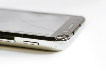 Old phone with broken screen isolated on white background