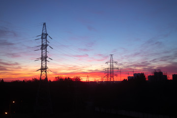 Power lines on a pink sky background. Sunrise over the forest