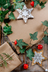 Christmas background with wooden stars, ivy leaves and beautifully wrapped gift.