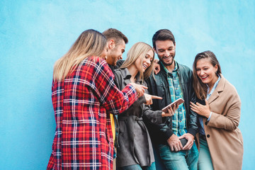 Group of friends watching videos on smartphone - Teenagers addiction to new technology trends - Youth, tech, social, millennial generation and friendship concept - Main focus on center girl face