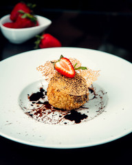 dessert with chocolate syrup and strawberry slice on top