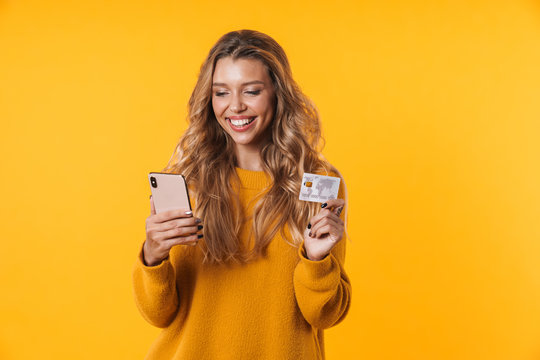 Image of beautiful blonde woman holding credit card and cellphone