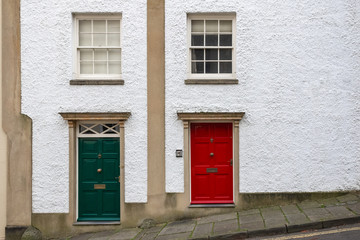 Fototapeta na wymiar Two house frontages decorated with green and red doors around Brandon Hill in Bristol, England