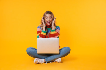 Naklejka premium Image of blonde woman using laptop computer while sitting on floor