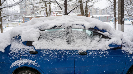 The car, covered with thick layer of snow. Negative consequence of heavy snowfalls. Side hundred...