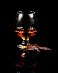 Obraz na płótnie Canvas glass of cognac and dark chocolate