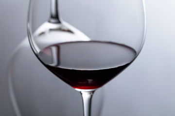 Glass of red wine on a black reflective background.
