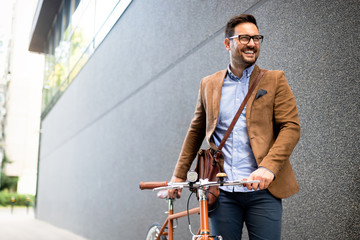 Happy businessman riding bicycle to work in morning