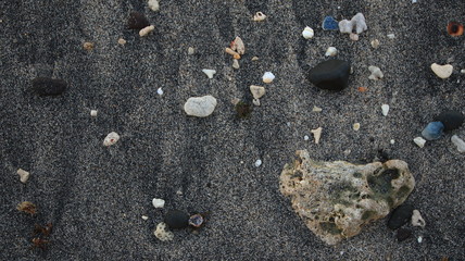 the rocks on the beach sand are gray in the morning, with less light, out of focus, suitable for the background