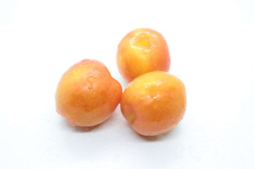 Orange wet tasty plums located on a white background