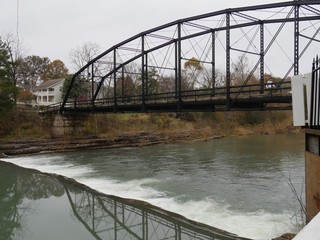 Bridge reflected in the waters of War Eagle river on a cold autumn morning at Benton County,...
