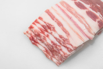 Sliced pork belly on a white background