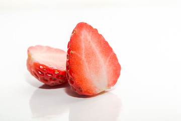 One cut strawberry placed on white background.