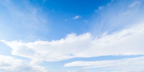 Light blue sky with layers of white clouds