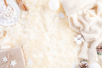 Fototapeta na wymiar Winter composition. Gift box marshmallow cup, Christmas ball snowflakes, anise stars, beige sweater on cream colour knitted blanket and fluffy background. Flat lay top view copy space.