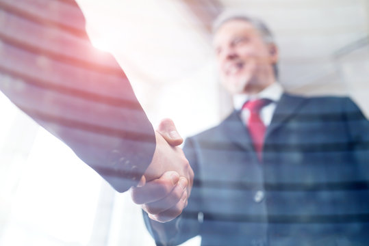 Business people shaking hands, double exposure effect