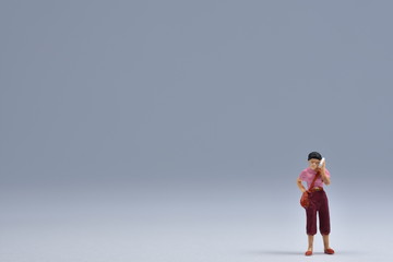 Obraz premium miniatuur woman standing is talking on a handy