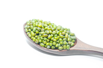 Wooden spoons of mung beans on a white background
