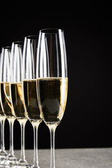 selective focus of champagne glasses with sparkling wine isolated on black