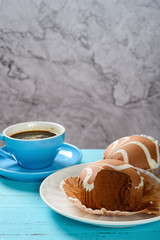 side view chocolate flavor cup cakes with a bite and cup of coffee nearby vertical composition