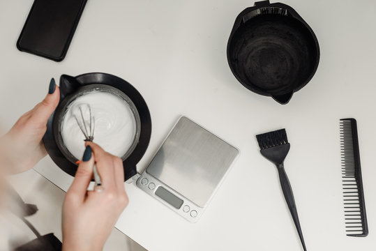 Closeup of professional hairdresser mixing hair dye in beauty salon