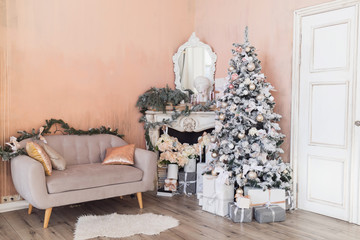 Luxury classic interior with a big pink  christmas tree, classic sofa with pillows and fireplace . Happy new year concept.