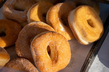 Fried donut with sugar at market
