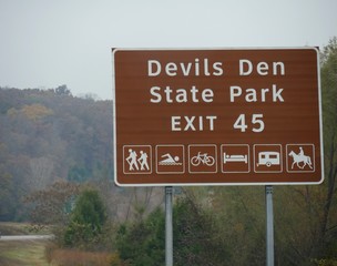 Directional sign for exit along Interstate 49 to the Devils Den State Park in Arkansas, USA.