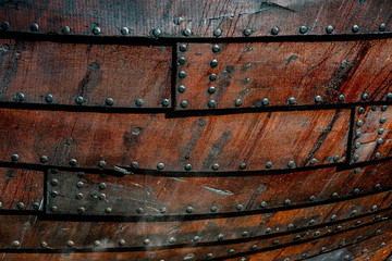 Close up of an old boat side with tared overlapped boards riveted together