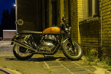 A motorcycle at night, a motorcycle stands under a street light, cruiser, vintage motorcycle