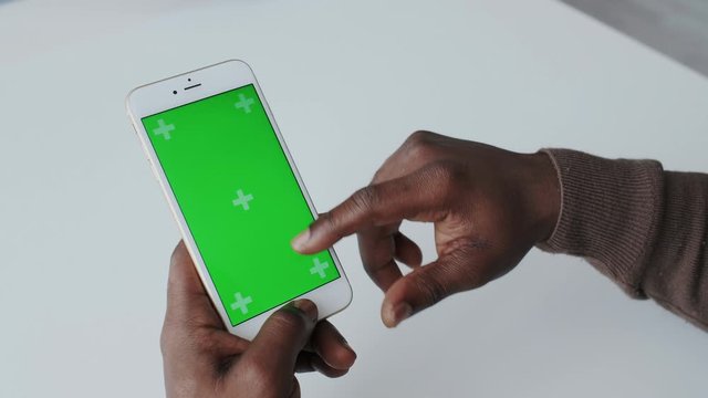 Greenscreen or Mock-up Tracking in African American Male Hands with Blank Background. Using Smartphone, Surfing web, Online Shopping. Scroll Up Apps, Tap keys, Sharing Social Media, Technology.