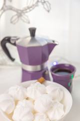 Coffee mug, coffee pot, lanterns, marshmallows on a wooden window sill