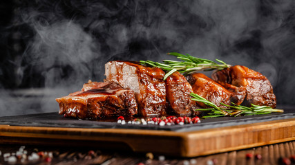 American food concept. Grilled pork ribs with grilled sauce, with smoke, spices and rosemary....