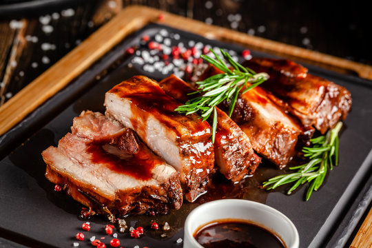 American food concept. Grilled pork ribs with grilled sauce, with smoke, spices and rosemary. Background image. copy space