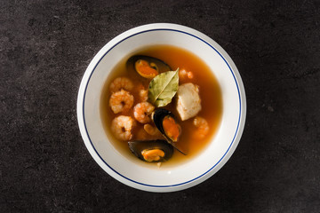 French bouillabaisse soup on black background. Top view