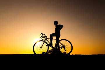 Obraz premium cyclist and Bicycle silhouettes on the dark background of sunsets. ride bicycle on sunset background.