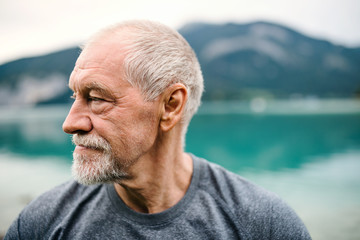 A close-up portrait of senior man pensioner standing outdoors in nature.