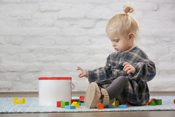 Toddler girl playing with colorful wooden blocks	