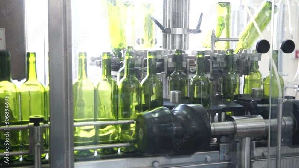 Poster automated machines with wine bottles being filled at a alcohol factory