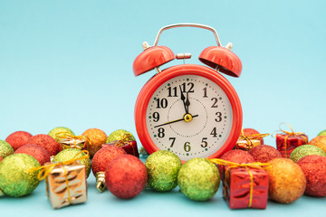 red alarm clock in Christmas toys on blue background