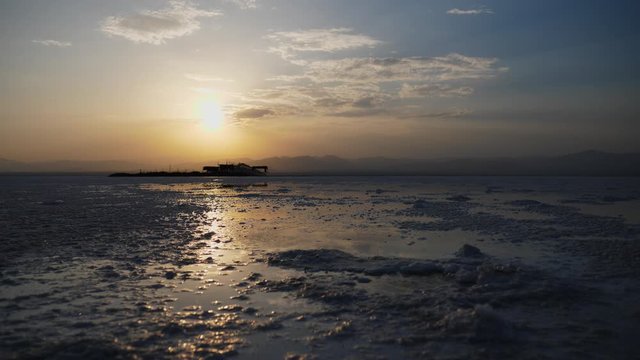 Steady shot focusing on the water of Danakil Salt Flats. Stunning Sunset in the background.